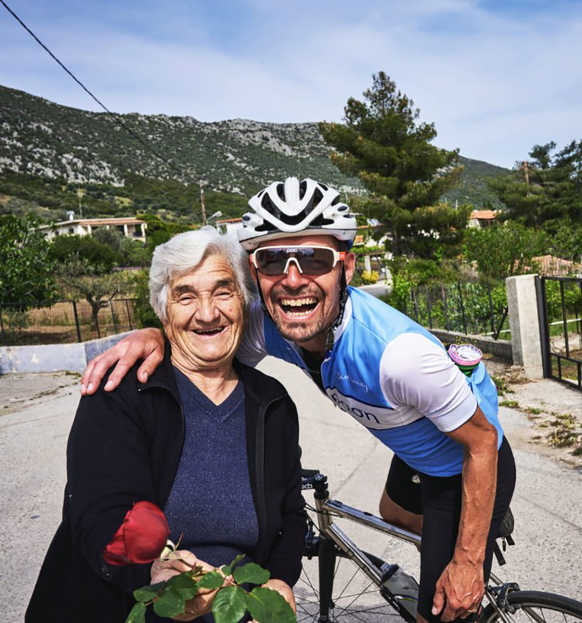 cyclist Chris Ward, smiling with a local Greek woman